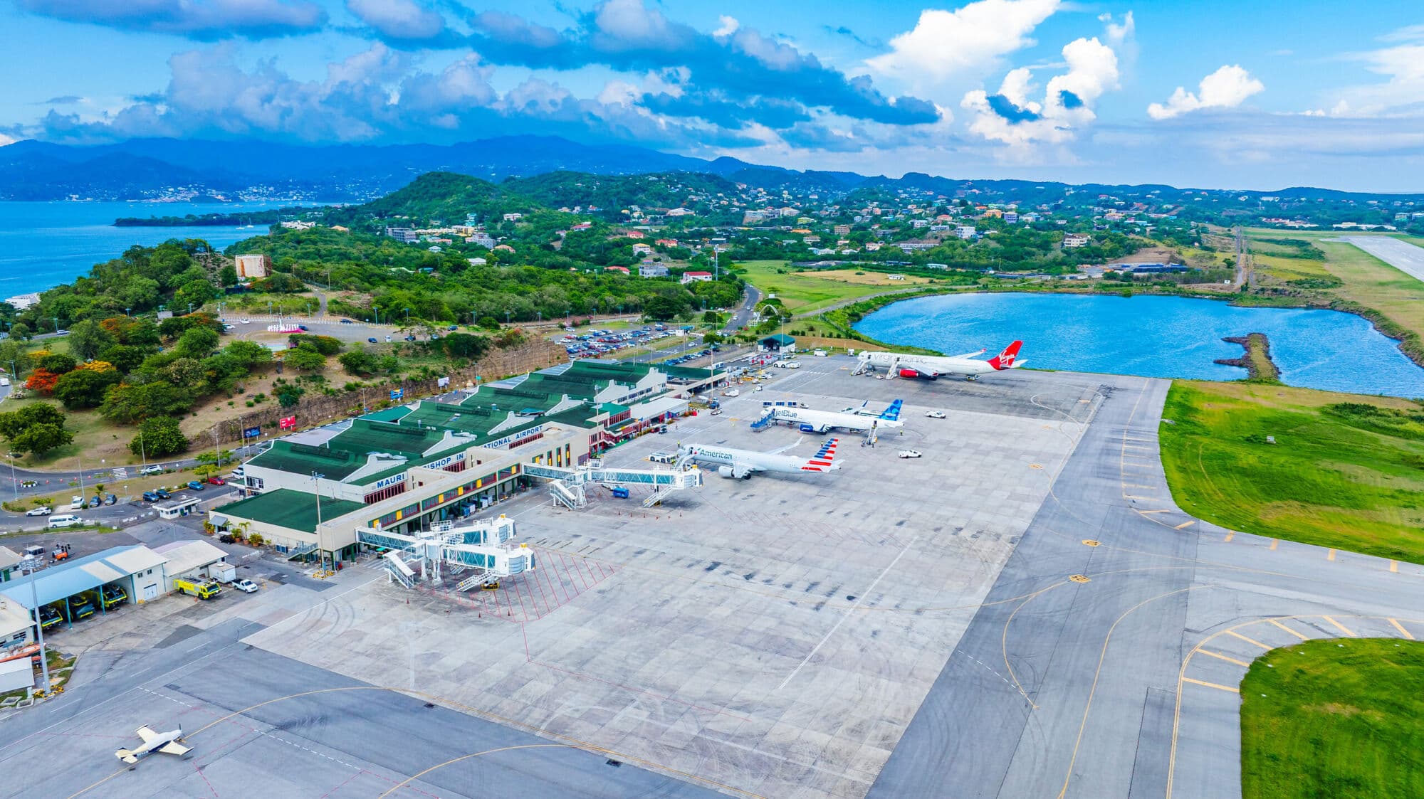 Aerial view of Maurice Bishop International Airport between the hills and the Caribbean Sea
